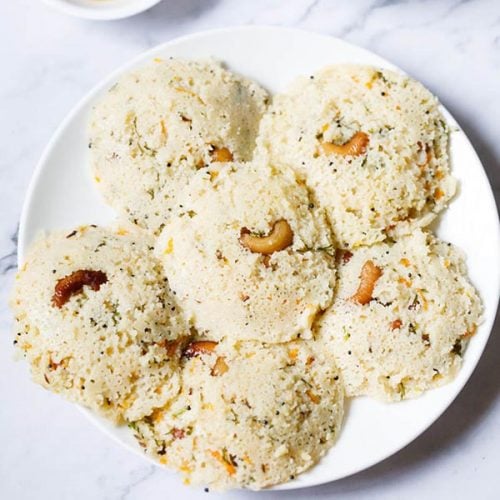 rava idli served on a white plate.