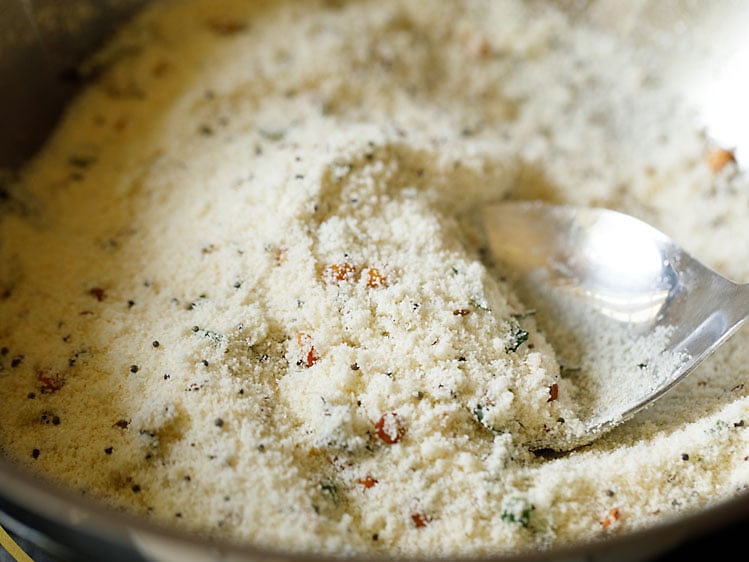 mixing rava with ghee for making suji ki idli. 