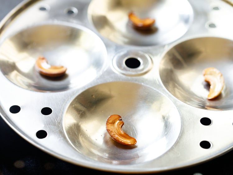greased idli pan moulds with cashews