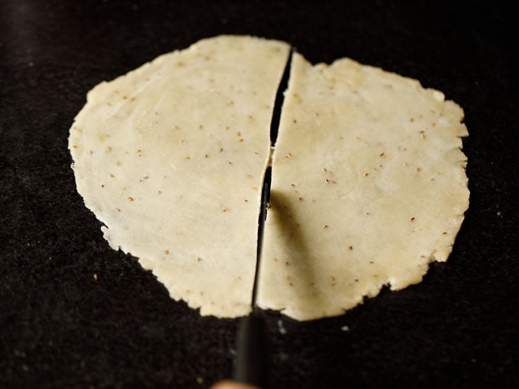 rolled dough being cut in half