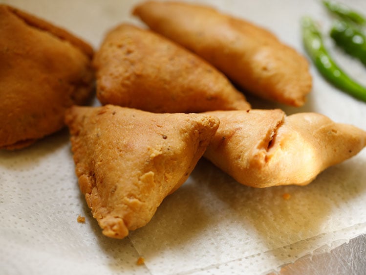 fried punjabi samosa placed on white kitchen paper towels