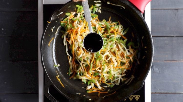 soy sauce being added to the stir-fried vegetables