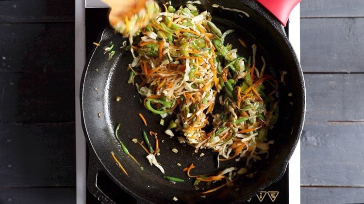 mixing the seasoning with the stir-fried vegetables