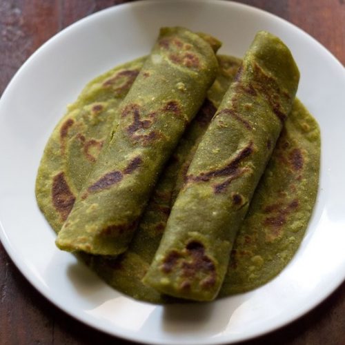 aloo palak paratha on a white plate.