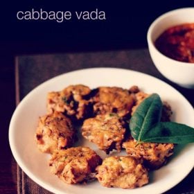 cabbage vada with a two leaf sprig of curry leaves served on a white plate with tomato chutney in white bowl in the background