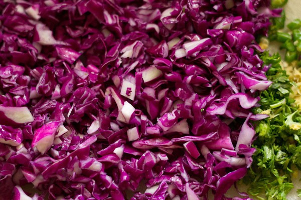 chopping cabbage, ginger, green chilies and coriander leaves