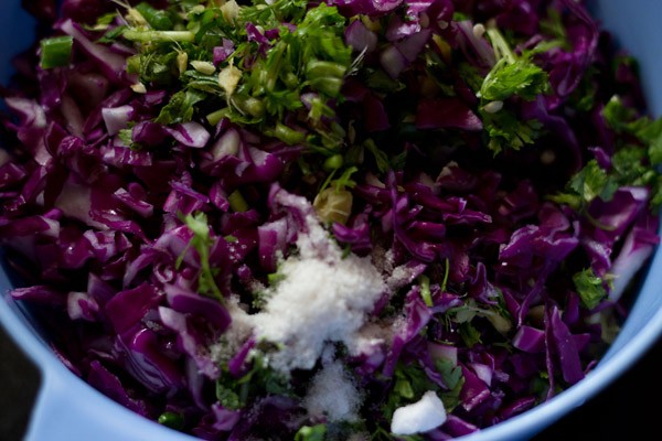 adding chopped vegetables, chopped curry leaves and salt to vada batter 