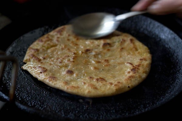 roasting dal paratha on tava