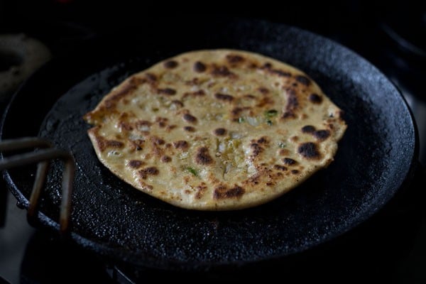 cooked dal paratha on skillet