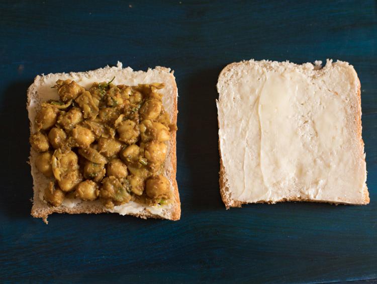 chana masala spread on one buttered bread slice.