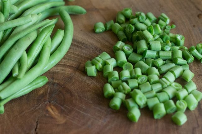 chopping french beans on a chopping board