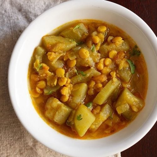 lauki chana dal served in a white bowl.