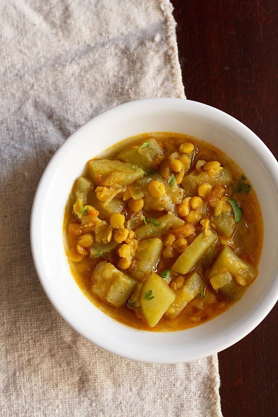 lauki chana dal served in a white bowl.