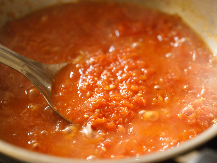 checking the pizza sauce while it is simmering