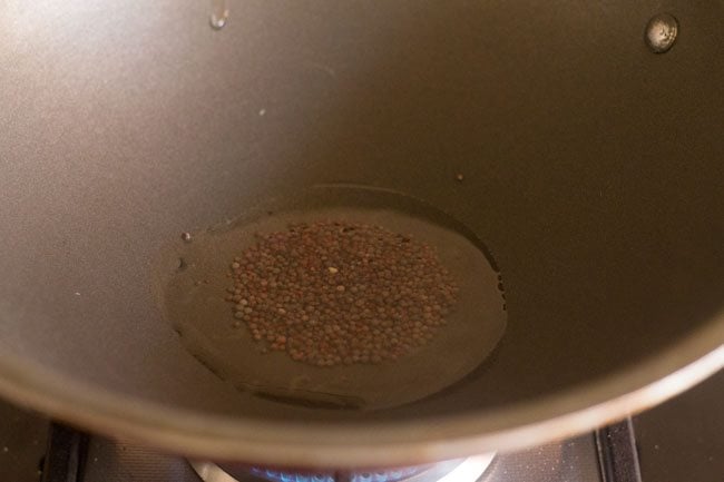 mustard seeds crackling in hot oil in a pan. 