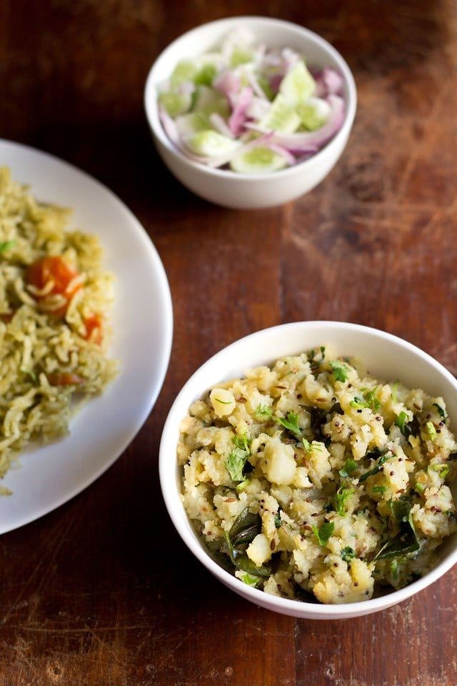 potato podimas served in a white bowl with a plate of masala rice and a small bowl of cucumber and onions kept with it.