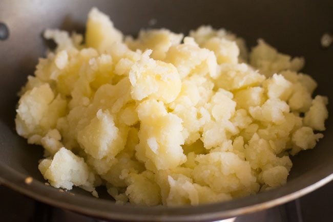 mashed potatoes added to the pan for potato podimas recipe. 