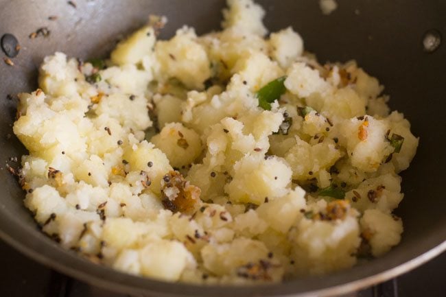 sautéing potato mixture for potato podimas recipe. 