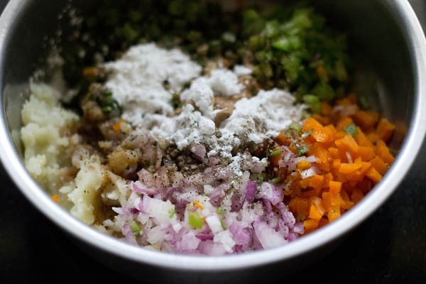 chopped vegetables. mashed potatoes, finely chopped ginger, finely chopped garlic, finely chopped green chili, cornstarch, soy sauce, salt and black pepper added in a bowl. 