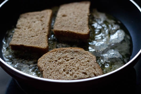 sesame toasts placed upside down in hot oil and fried. 