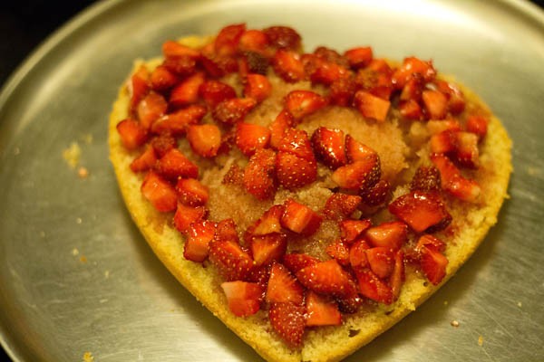 strawberries and macerated juice placed on top of cake.