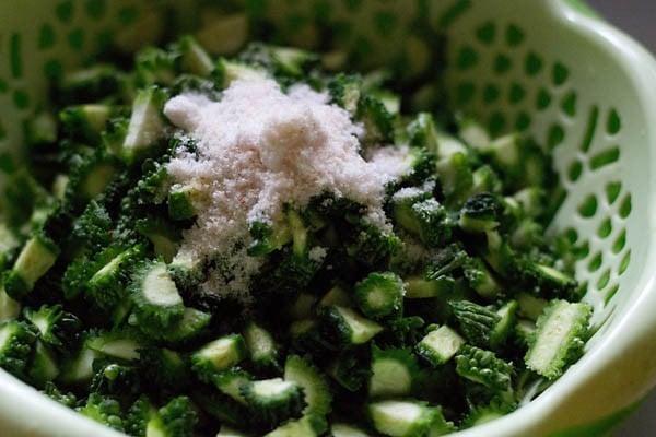 mixing salt with bitter gourd pieces. 