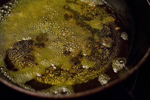 adding fenugreek seeds and mustard seeds to the hot oil. 