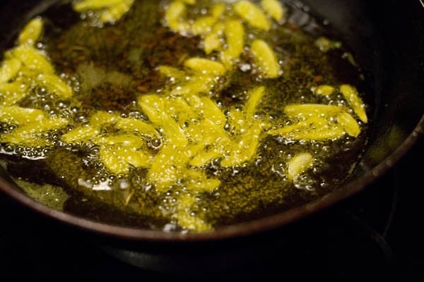 adding sliced garlic to the hot oil and frying. 