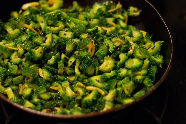 adding bitter gourd pieces in the pan. 