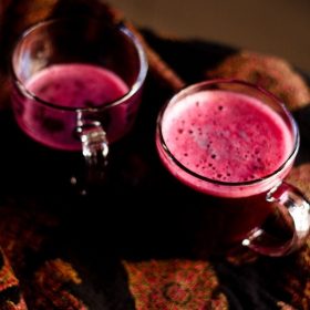 dark purple colored grape juice in two glass mugs.