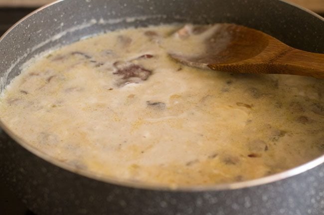 cream mixed with mushroom soup with a wooden spoon 