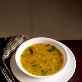 khatti meethi dal served in a white bowl.