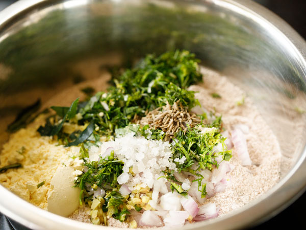adding onions, spices, herbs and salt to the bowl