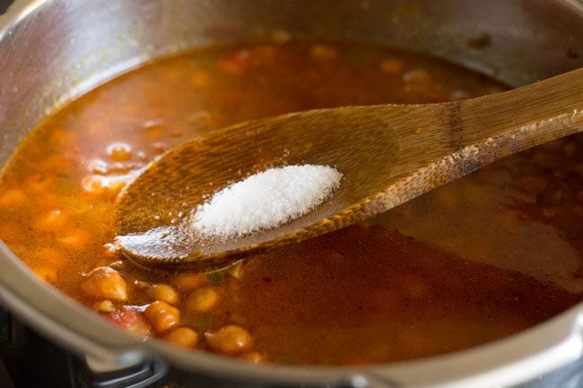 salt being added to kala chana gravy recipe