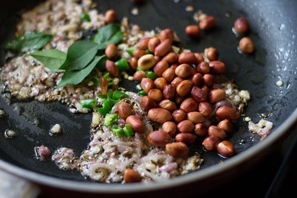 curry leaves, chopped green chilies and roasted peanuts added to the pan. 