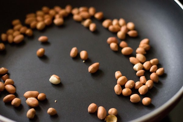 dry roasting peanuts in a pan for kanda batata poha. 