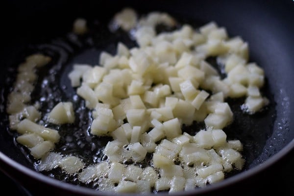 sautéing potatoes in hot oil for kanda batata poha. 