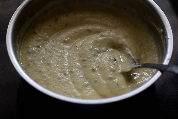 mixing the crushed spices in the prepared moong dal batter. 