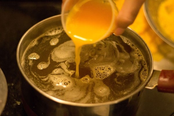 adding orange juice to sugar syrup. 