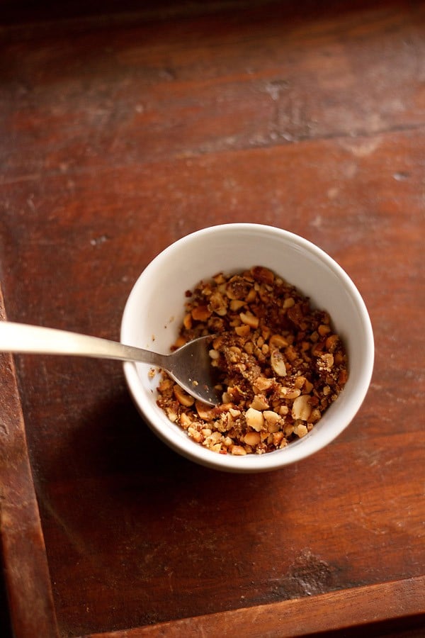 thecha served ina small white bowl with a spoon in it.