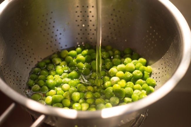 rinsing peas in a colander.