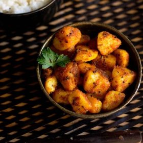 potato roast garnished with a coriander leaf served in a bowl.