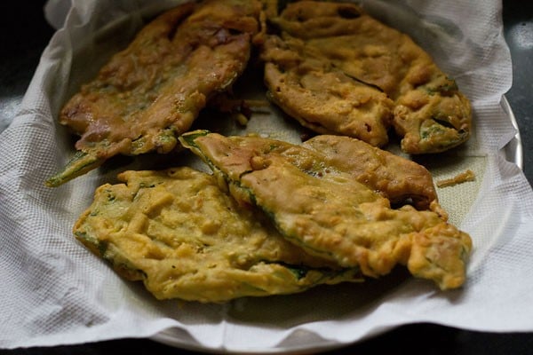 fried spinach fritters placed on kitchen paper towels