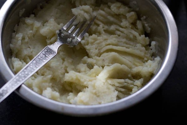 mashed boiled potatoes in a bowl for aloo bonda recipe. 