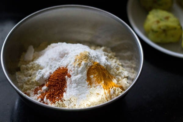 Add gram flour, rice flour, spice powder, baking soda and salt to another mixing bowl to make a batter. 