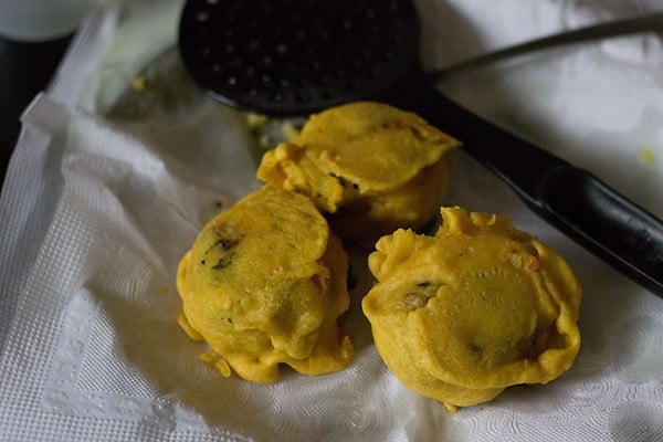 fried aloo bonda placed on kitchen paper towel. 