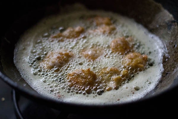 frying chana dal pakora in hot oil in a kadai