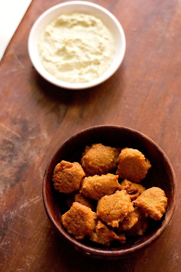 chana dal pakora served in a round bowl with a side of chutney