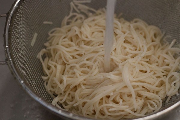 cooked hakka noodles being rinsed in fresh water