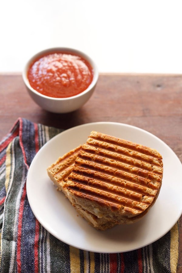 potato sandwich served in a white plate with ketchup in a bowl